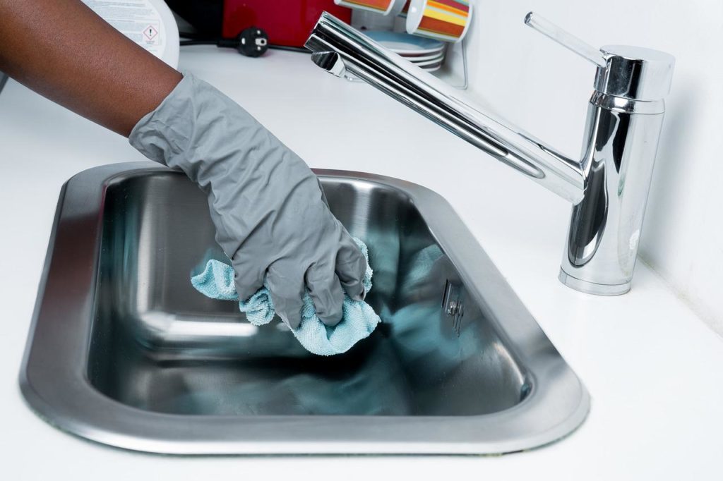 Cleaning kitchen sink in the kitchen. Part of the Spring Cleaning Tips for a clean home.